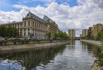 Fototapeta na wymiar Bucharest, Romania - April 12, 2016: Dimbovita River and the Justice Palace in Unirii Square.