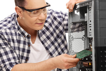Fototapeta na wymiar Young PC technician assembling a computer