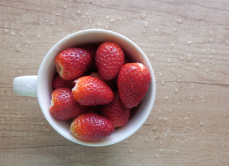 Color detail photography of fresh red strawberries in white pottery cup
