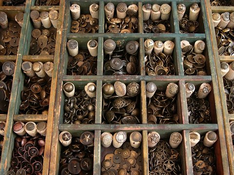 Alte traditionelle Kn&ouml;pfe aus Kupfer und anderem Material in einem Setzkasten auf dem Mittelaltermarkt in Gro&szlig;auheim am Main bei Hanau im Main-Kinzig-Kreis in Hessen