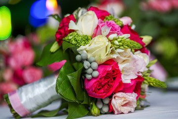 Wedding bouquet of bride colorful roses on the white table
