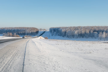 Fototapeta na wymiar Highway through the forest. Winter road.