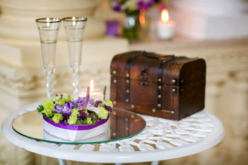 Decor wedding ceremony colorful flowers, candle, glasses and chest