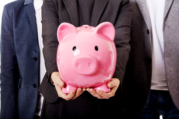 Business team-two men and woman holding piggybank