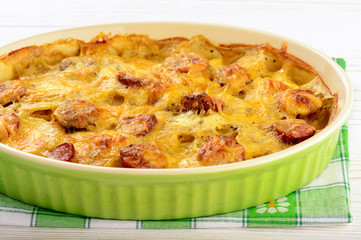 Casserole with potatoes, sausages, tomatoes and cheese.