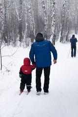 father teaches a child to ski