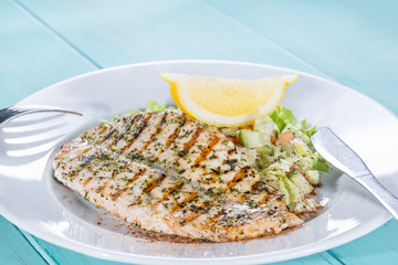salmon fillet on the grill serve fresh salad and lemon