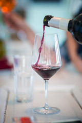 Pouring red wine in wine glass
