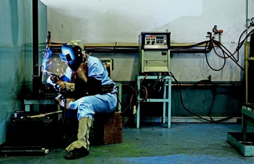 welder with protective mask welding metal and has spark splash - obrazy, fototapety, plakaty