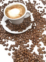 Taza con café con leche y granos de café