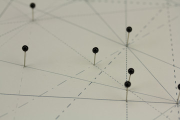 Black pins in paper linked by lines