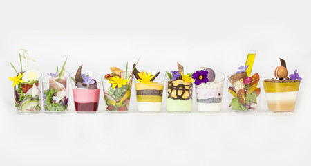 mini canapes in plastic cups decorated with edible flowers