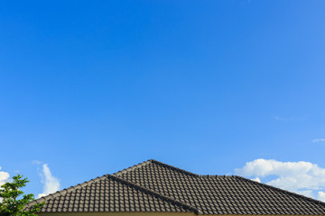 Fototapeta na wymiar black tile roof on a new house with clear blue sky background