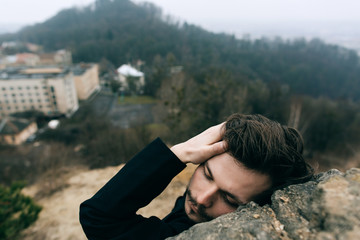 Portrait of handsome catholic bearded man priest or pastor posing outdoors in mountains