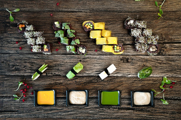 Vegan Sushi  Set with different types of sauce on wooden table. Top view.