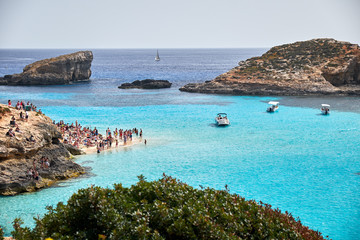 BLUE LAGOON, COMINO, MALTA - APRIL 13, 2016. People enjoy blue lagoon  with crystal clear blue water. © twindesigner