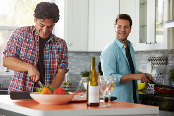 Fototapeta na wymiar Male gay couple preparing a meal together in the kitchen