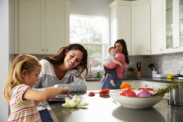 Mother and daughter using digital tablet in kitchen - Powered by Adobe