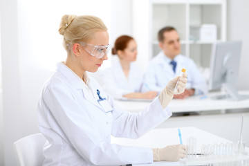 Scientific research team with clear solution in laboratory