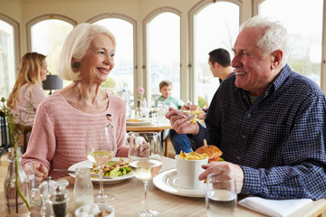 Senior Couple Enjoying Meal In Restaurant Together