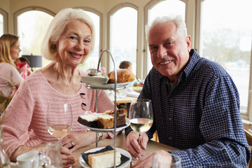 Senior Couple Enjoying Afternoon Tea In Restaurant Together