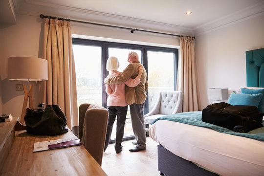 Senior Couple Arriving In Hotel Room On Vacation