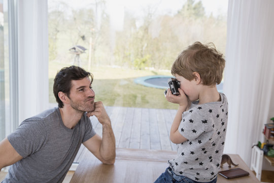 Father and son playing with camera