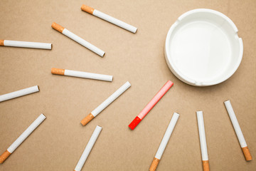 Business goal concept : cigarette and ashtray with brown background