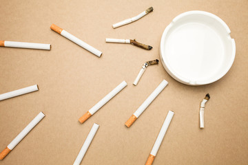 Business goal concept : cigarette and ashtray with brown background