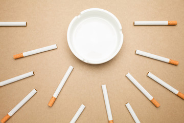 Business goal concept : cigarette and ashtray with brown background