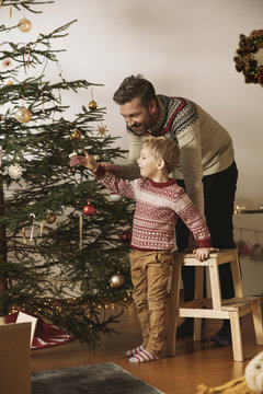Father and son decorating Christmas tree