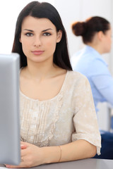 Young businesswoman sitting at desk and working