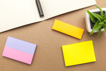 Blank paper,book,pen and plant on brown background