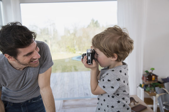 Father and son playing with camera
