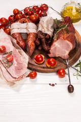 Antipasto catering platter with salami and meat on a wooden background