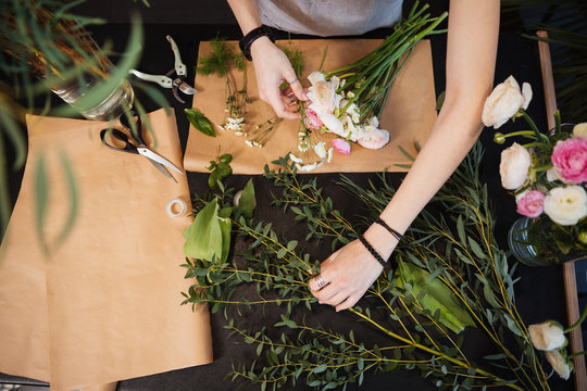 Hands Of Woman Florist Creating Flower Bouquet On Table