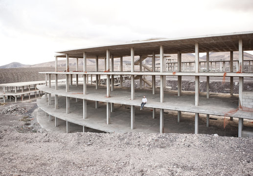 Spain, Fuerteventura, Jandia, architect sitting in building shell