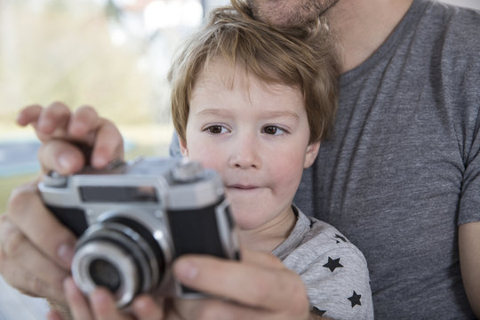 Father and son playing with camera