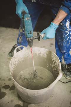 Bricklayer mixing cement in bucket