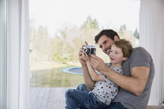 Father and son playing with camera
