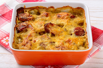Casserole with potatoes, sausages, tomatoes and cheese.