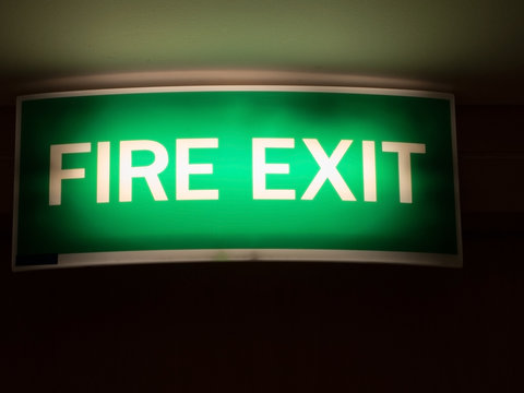 Fire Exit Sign. Light Green Emergency Fire Exit Sign In The Office/hotel Shows People Way Out.