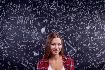 Student against a big blackboard with mathematical symbols