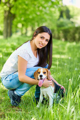 Portrait of a young girl with her dog in the park..