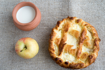 Cheesecake, pot and apple on natural burlap