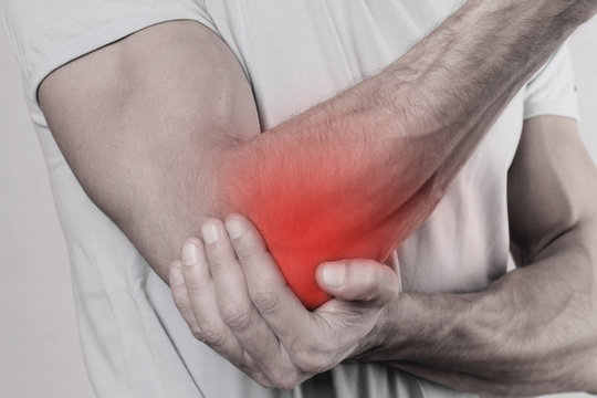 Man With Pain In Elbow. Pain relief concept
