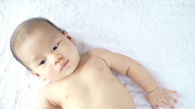 Asian baby playing on a blanket