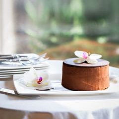 Delicious chocolate cake on white table