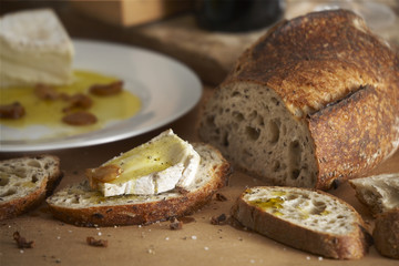 Tuscany country side table with bread,cheeses,wine,and olive oil.