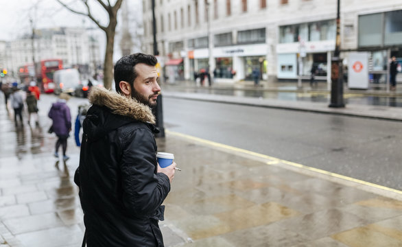 UK, London, man with coffee to go on a rainy day